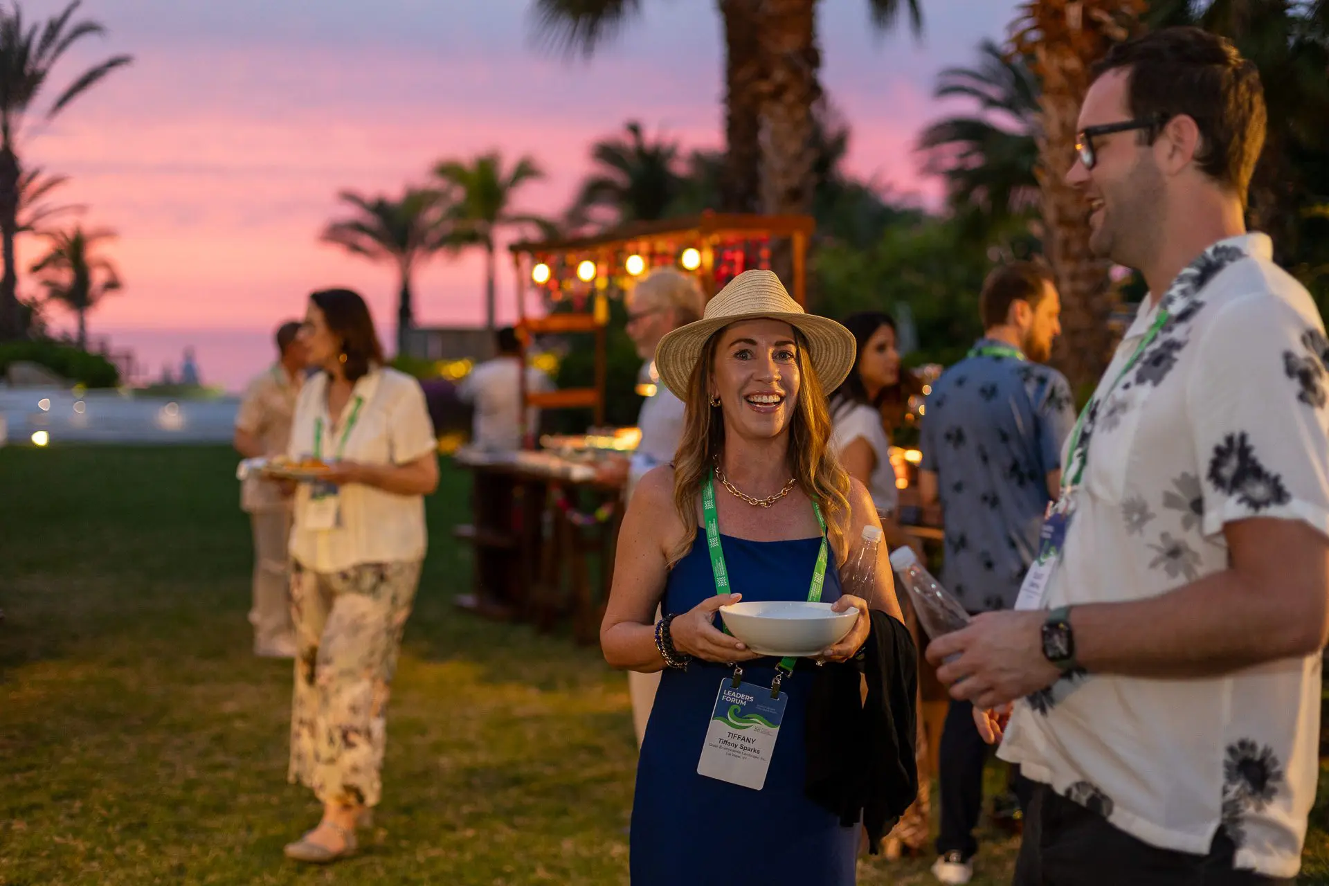 Grupo de personas posando al atardecer con atuendos elegantes.