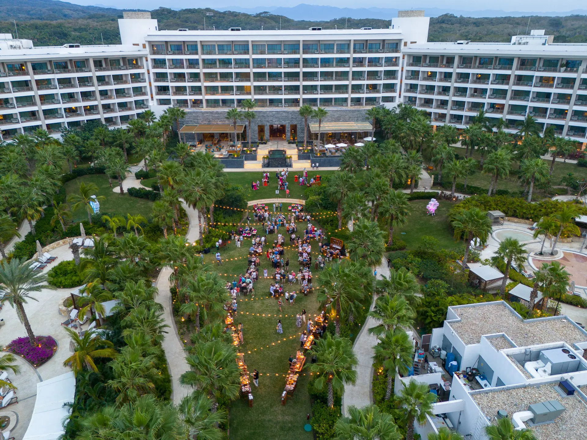Vista aérea de un lujoso resort con exuberantes jardines y piscinas.