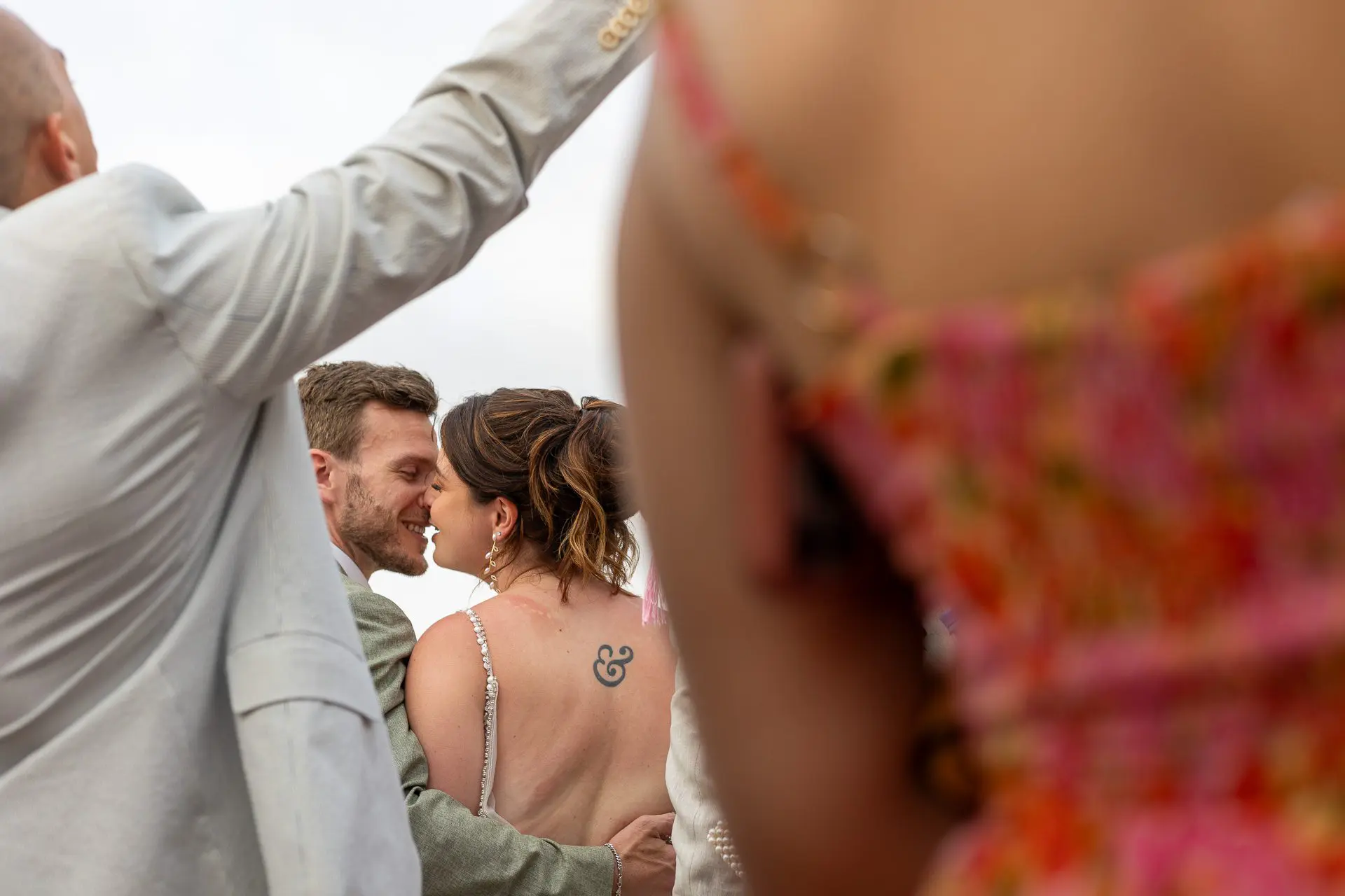 Bride and groom kiss through a crowd of people