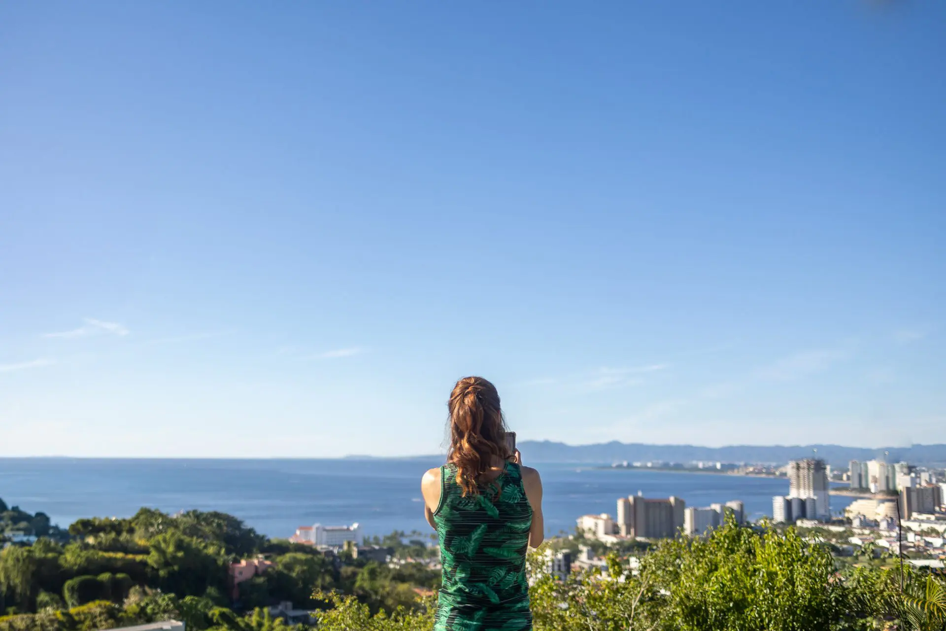 Mujer tomando una fotografía de Puerto Vallarta desde arriba