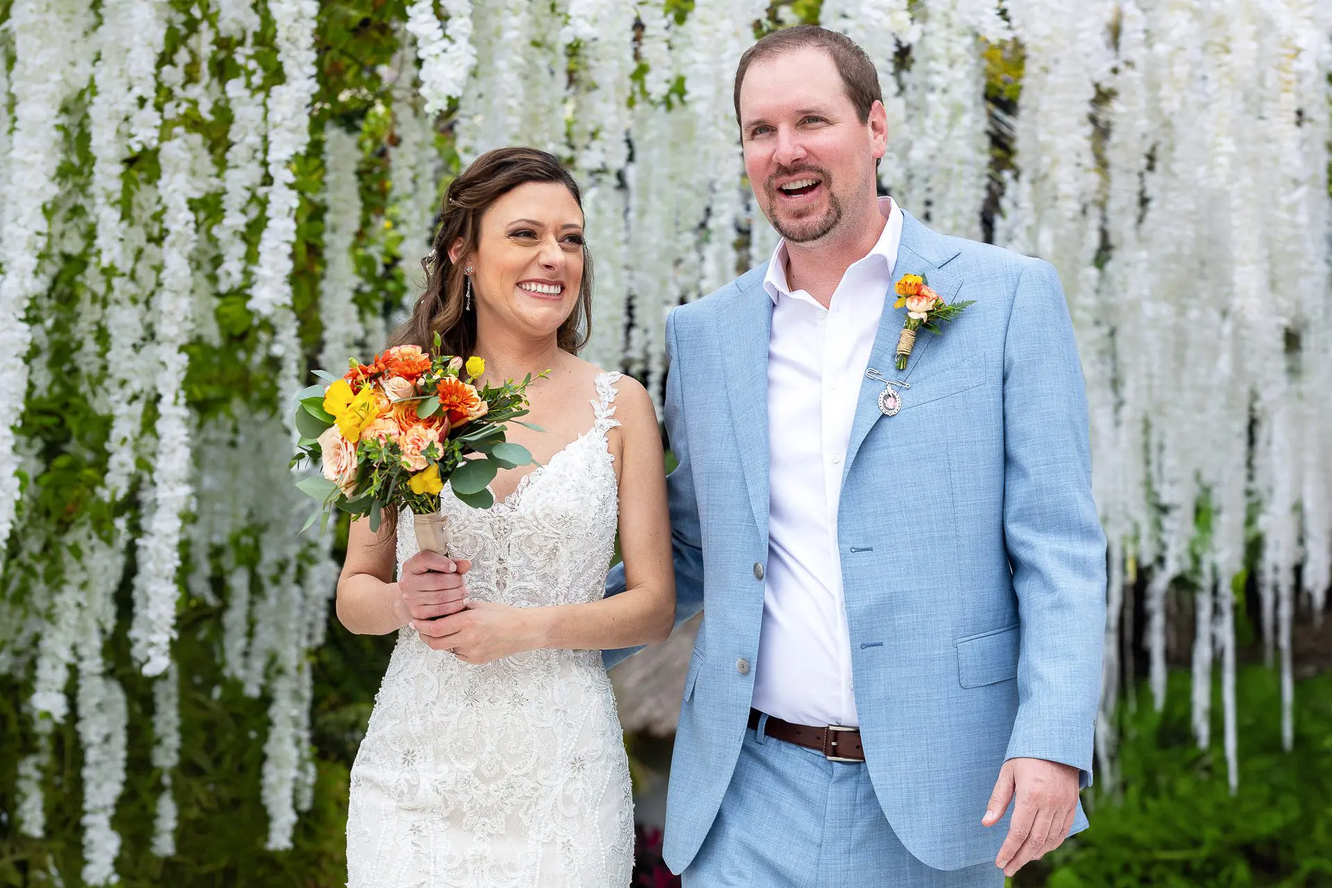 Bride and groom smile under a white wisteria tree at a top wedding venue in Cabo San Lucas, Baja California, Mexico