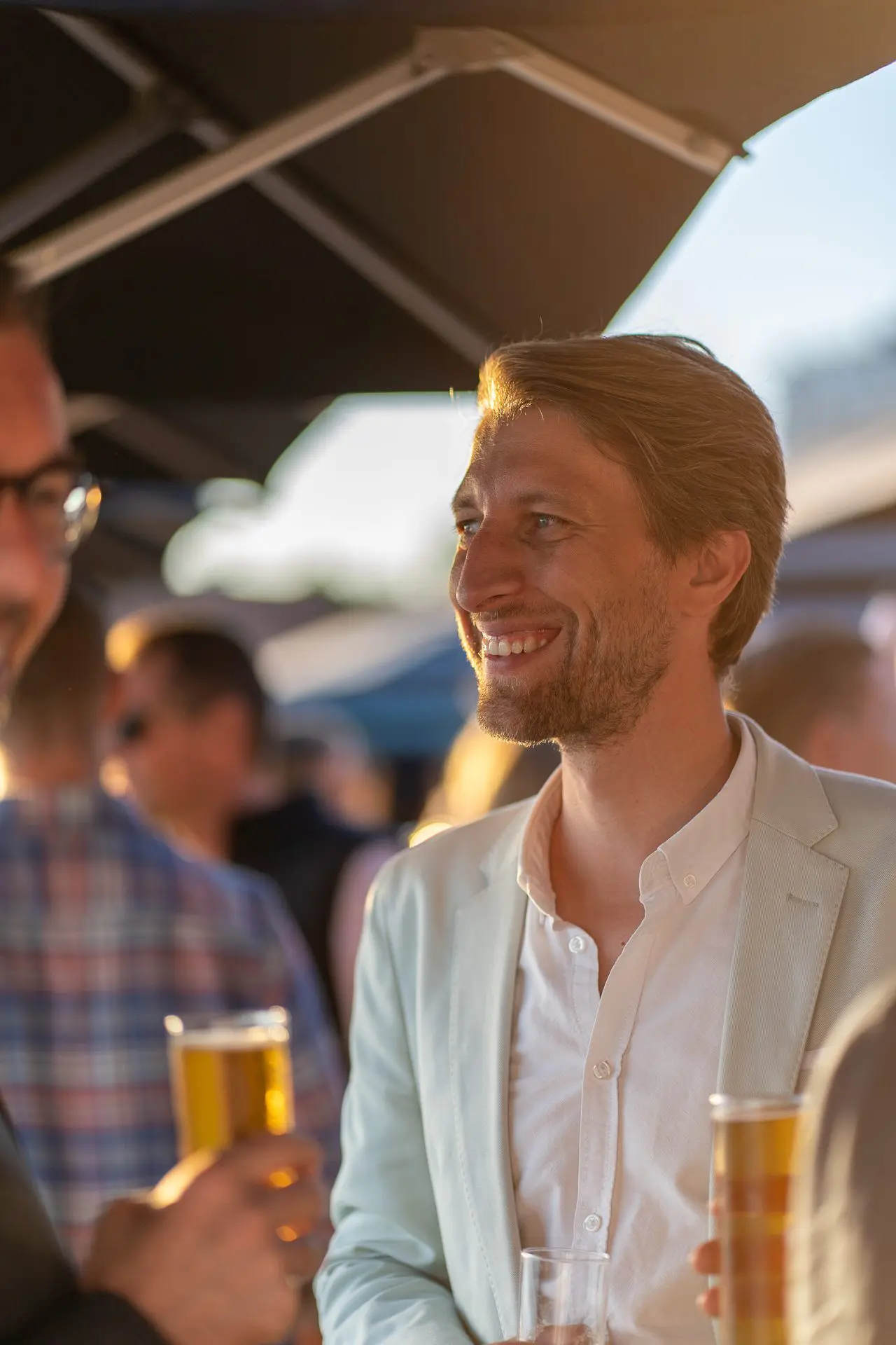 Los invitados se reúnen en un evento de networking frente al mar, tomando bebidas y participando en animadas conversaciones.