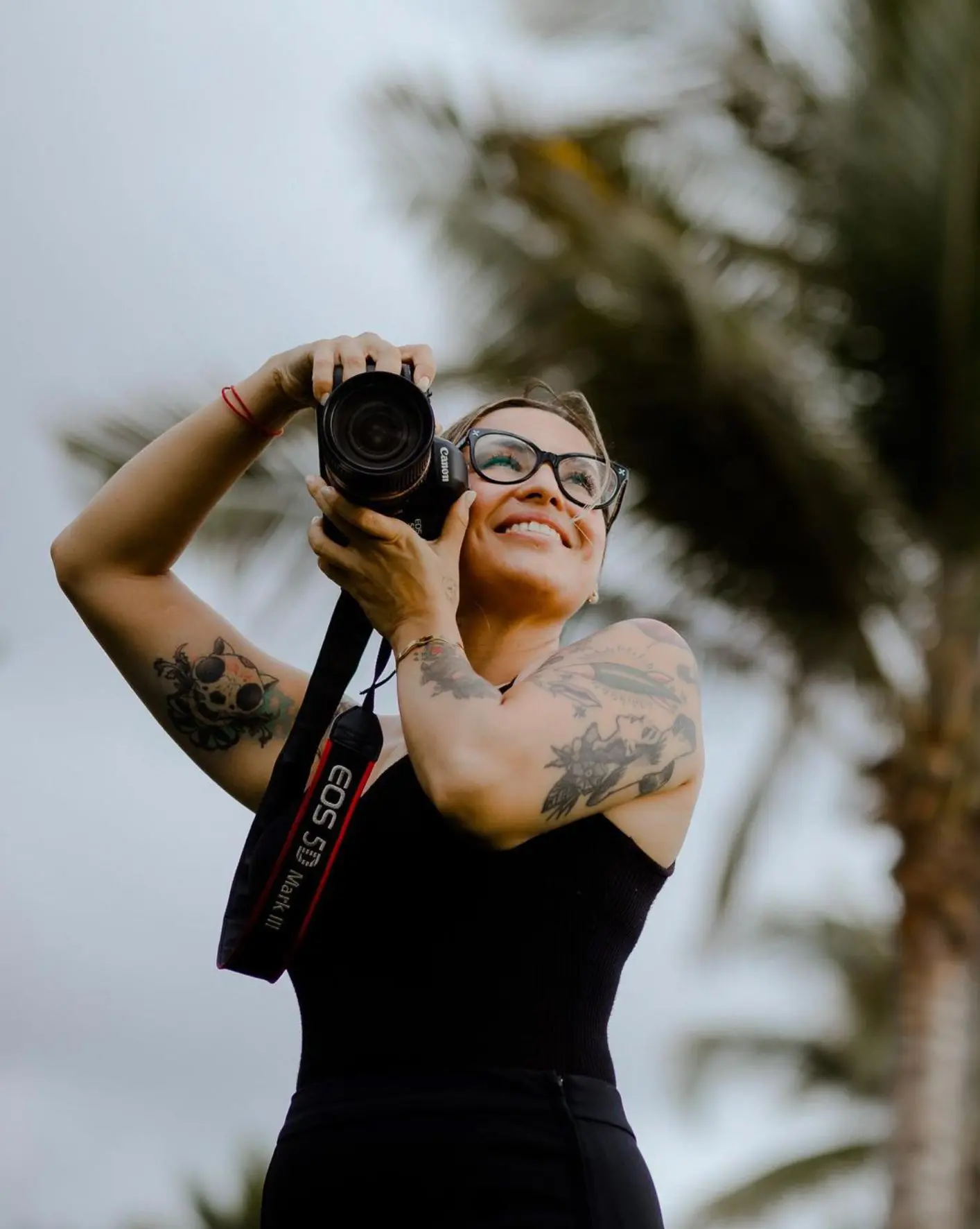 Photographer holding a Canon camera and smiling
