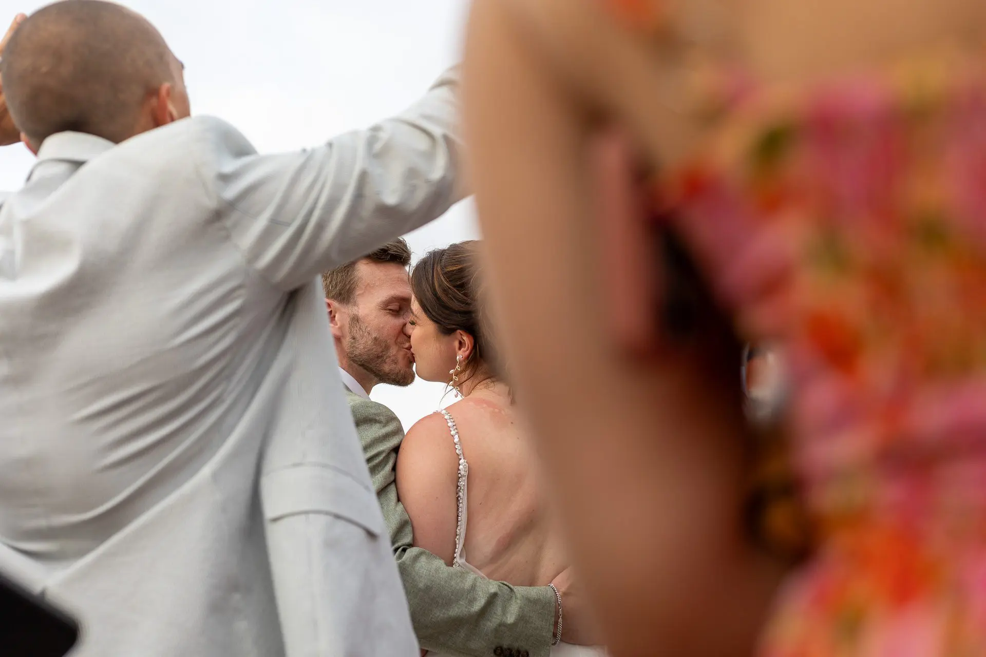 A candid moment of a bride and groom sharing a kiss during their wedding celebration.