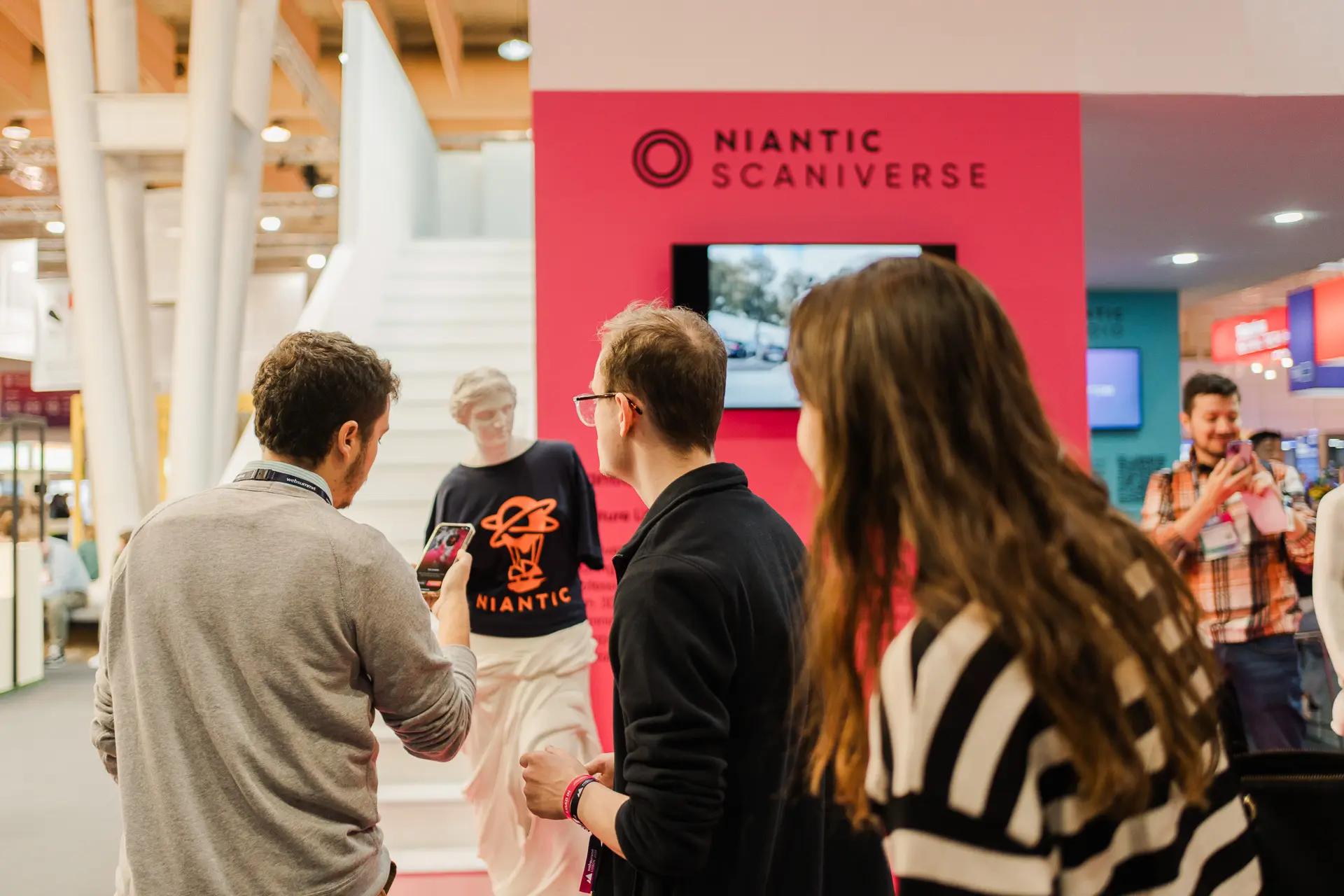 Hombres mirando un teléfono en el evento corporativo de Niantic en Lisbon Web Summit 2024