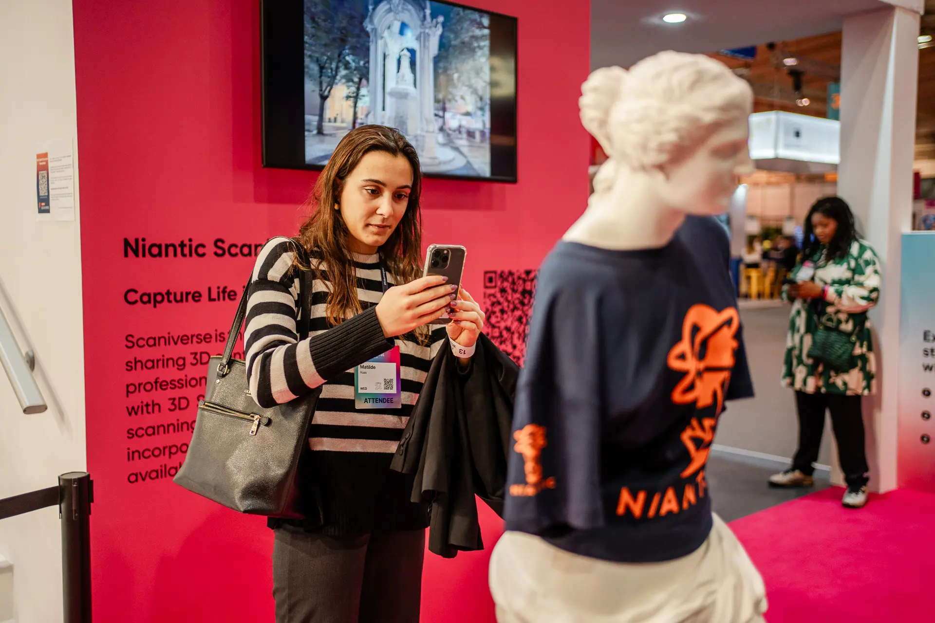 Una mujer se toma una foto con su teléfono en el evento corporativo de Niantic en el Lisbon Web Summit 2024